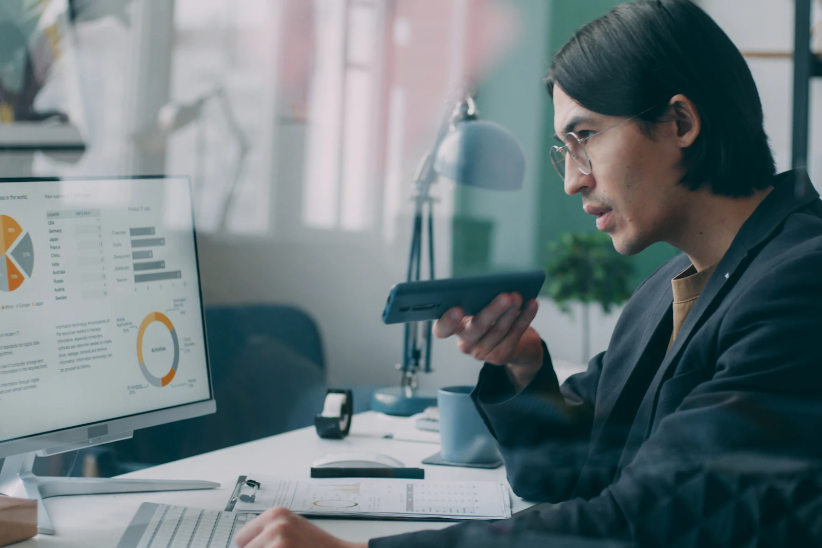 Analyst reviewing pie and bar charts on a desktop monitor