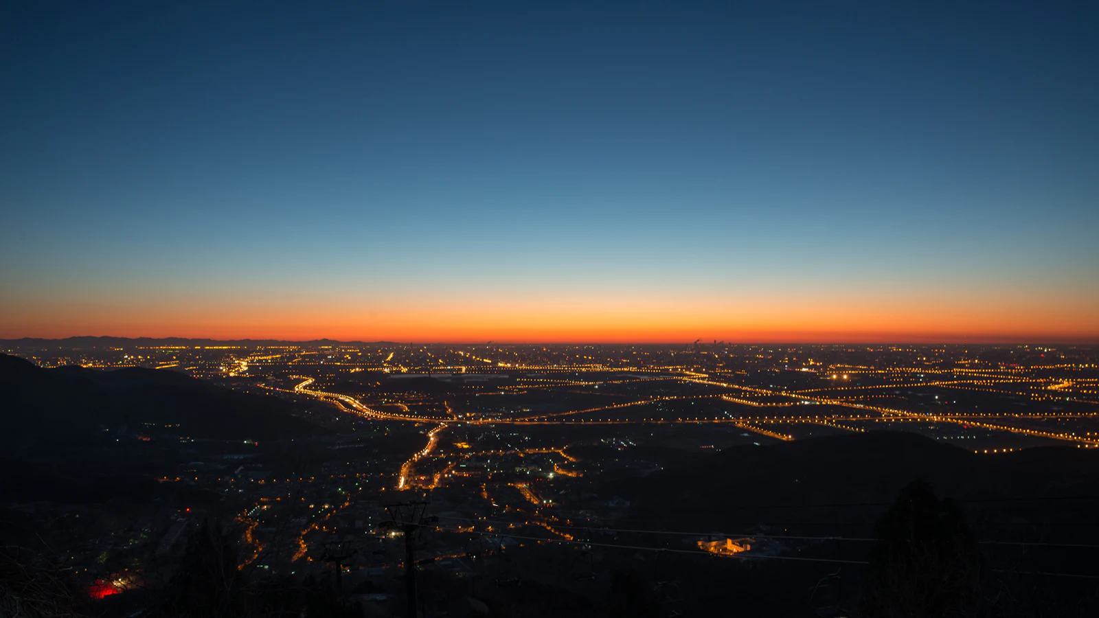 City lights spreading across a valley at dusk