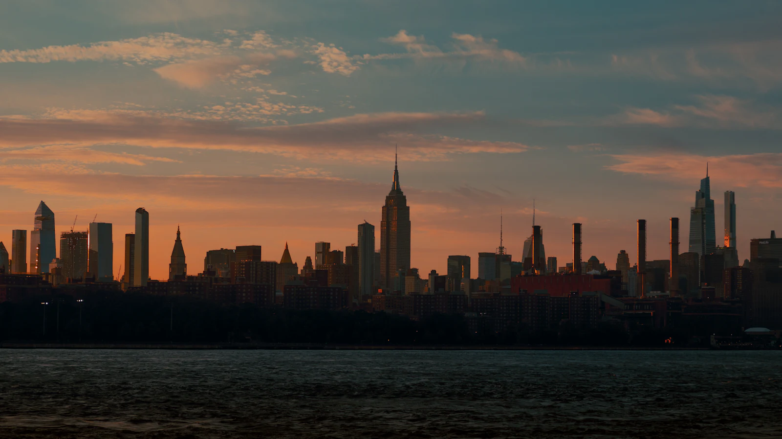 City skyline in silhouette across the water at dusk